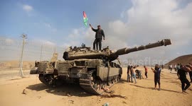 Palestinian stands on destroyed tank near border with Israel