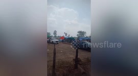 Tent flies away as storm whips through field in Thailand