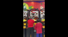 Cute pensioner couple play basketball arcade game together