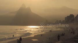 People on the beach in Rio de Janeiro enjoying the sun and the sea.