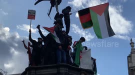 Protesters chant “Allahu Akbar” as they climb the Eros statue in Piccadilly Circus
