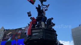 Riot police remove pro-Palestine protesters who climbed the Eros statue in Piccadilly Circus