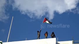 Pro-Palestine March at Piccadilly Circus with flags of Palestine flying on the roof of Trocadero building - London