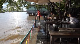 Diners eat with their feet in water as river level rises and floods restaurant