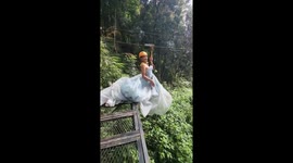 Thrill-seeker wears evening gown on zip line across waterfall in Laos