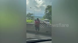 Motorist catches escaped piglet on expressway in Thailand