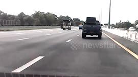 Leather armchairs fly fall from back of pickup truck on Thai motorway