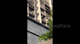 Heroic Chinese man holds up girl dangling from balcony until firefighters arrive