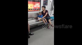 老人地铁上用玩具铁锹铲空气哄孩子开心 素材
