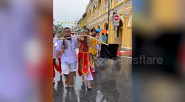 Taoist followers stab guns and bamboo poles through their mouths at Phuket Vegetarian Festival