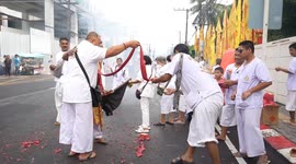 Devotees light firecrackers as they join parade at Phuket Vegetarian Festival