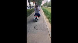 Woman rides wonky e-bike along path in China