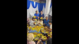 Easy on the confetti! Newlyweds covered in yellow blossom by wedding well-wishers