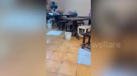 Filthy flood cascades into restaurant during storm in Thailand