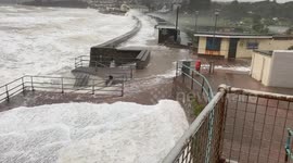 Storm Babet: Beach huts damaged as waves crash over seawall in Devon town
