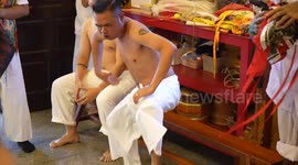 Possessed spirit mediums pray at shrine before piercing their cheeks with skewers for Thai Vegetarian Festival