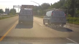 Workers fist bump while driving next to each other on freeway, near collision.