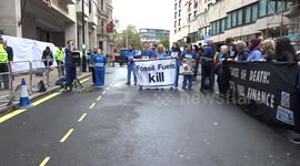 Climate activists dressed as doctors demand climate justice outside the Energy Intelligence Forum in central London