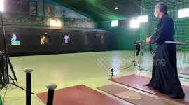 Elderly karate master uses sword to slice pitched baseball in half