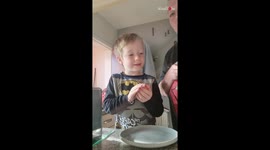 Startled young fella cracks a laughter after mom smashes egg on his head