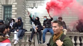 Smoke in colours of the flag of Palestine rises above Parliament Street at huge pro-Palestine protest in London