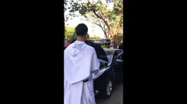 Priest blesses cars with Holy Water but also wets the driver