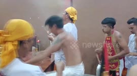 Taoist devotees walk on stepladder with rungs made from knives