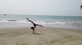 Eleonora, a young aspiring gymnast from Surgut, Russia practices her sports on Cavelossim beach while on a holiday in the Indian state of Goa