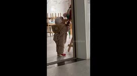 Toddler topples over while trying to pull backpack