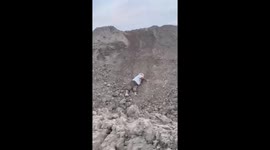 Happy toddler plays in soil on hillside in China