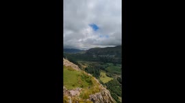 Climbing on one of the mountains in the lake district overlooking a beautiful deep coloured lake