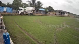Cement mixer truck rolls over while reversing on narrow dirt track