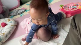 Caring baby boy helps to clean his little sister's mouth