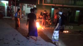 Indonesian kids take part in street game where they kick flaming ball