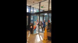 Staff and shoplifter get into tug-of-war at supermarket entrance