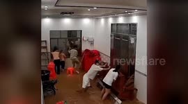 Family battle to stop flood surging through house door in China