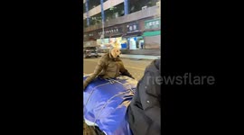 Elderly man dresses his dog in puffer jacket to beat the chill