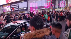 the crowd at times square cheers the sports cars during halloween party