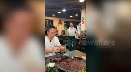Restaurant owner moves like robot to attract customers
