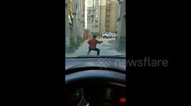 Elderly Chinese woman persists with Tai chi in road despite honking car