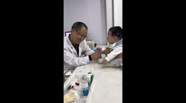 Doctor's playful approach soothes child during vaccination in China
