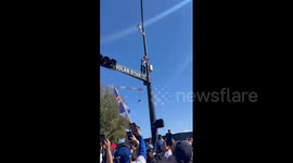 US: Fan Climbs Traffic Light Pole During Texas Rangers 2023 World Series Parade In Arlington