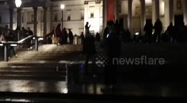 One of the Million Mask March protestors mimes to a song in Trafalgar Square