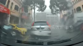Storm uproots tree sending it plunging onto car in Malaysia