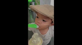 Toddler tries frozen yoghurt for first time and covers his face with the dessert