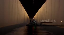 Rain pours from either side of bridge creating spectacular waterfall effect