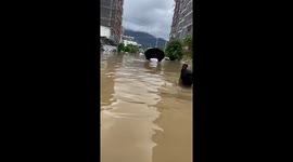 Chinese residents wade through chest-level floods after summer storm