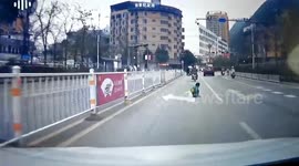 Chinese boy luckily avoids serious injuries after tumbling from scooter into path of oncoming car