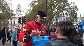 Red Poppy Appeal pins and wooden crosses on sale with crowds waiting for Field of Remebrance Opening 2023