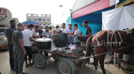 A Palestinian citizen distributes food to displaced Palestinians in Gaza Strip
